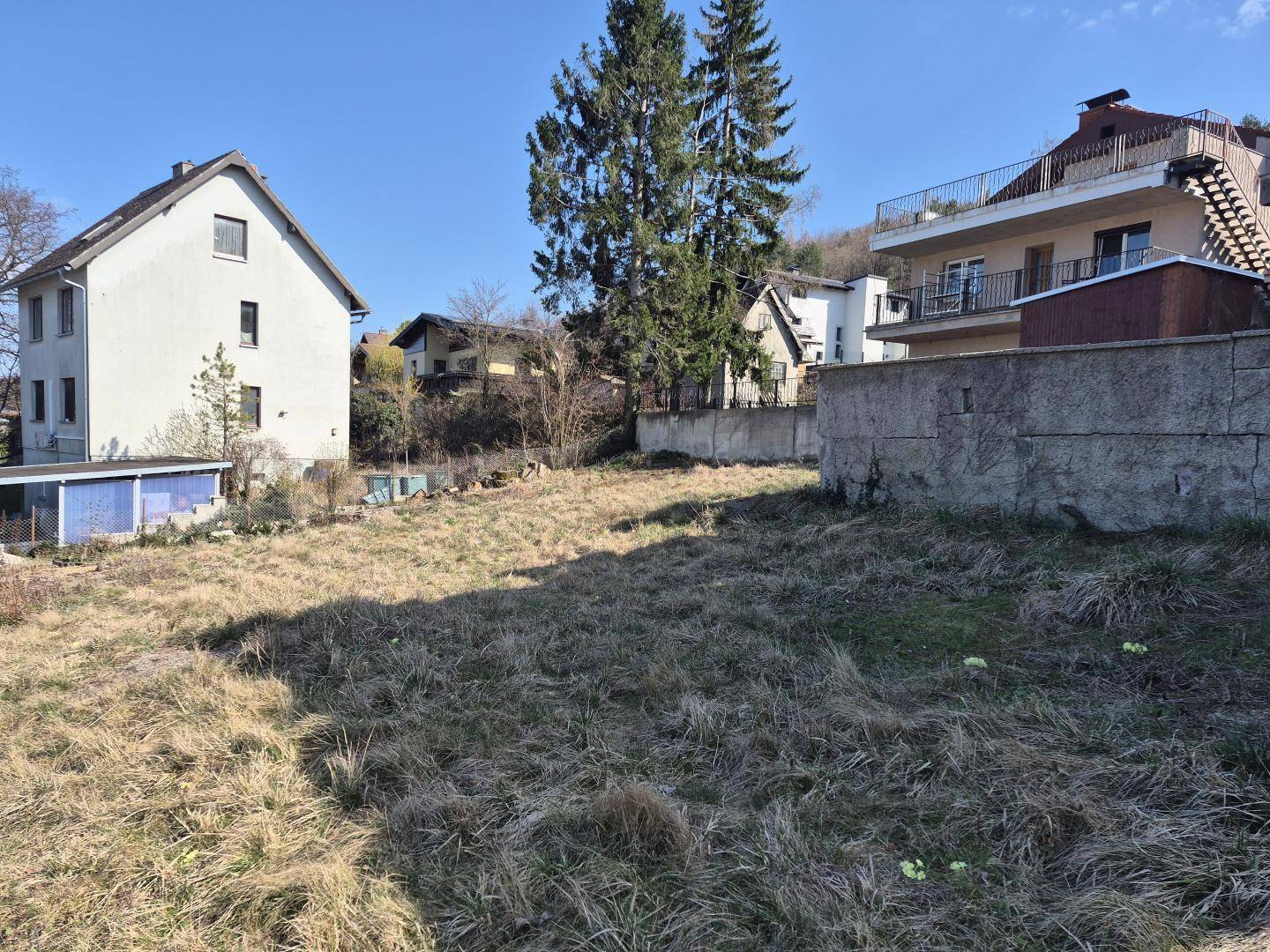 Weitläufiges, trockenes Grundstück mit Blick auf die umliegenden Wohnhäuser und die Landschaft.