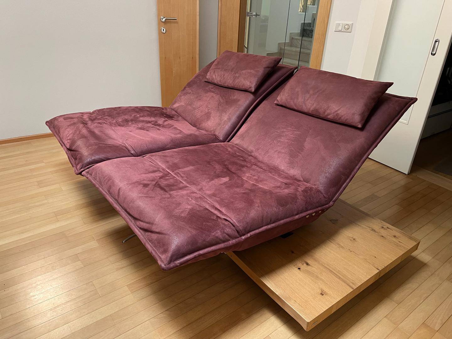 Bequeme Liegesofas auf Holzpodest im hellen Wohnzimmer mit Holzboden.