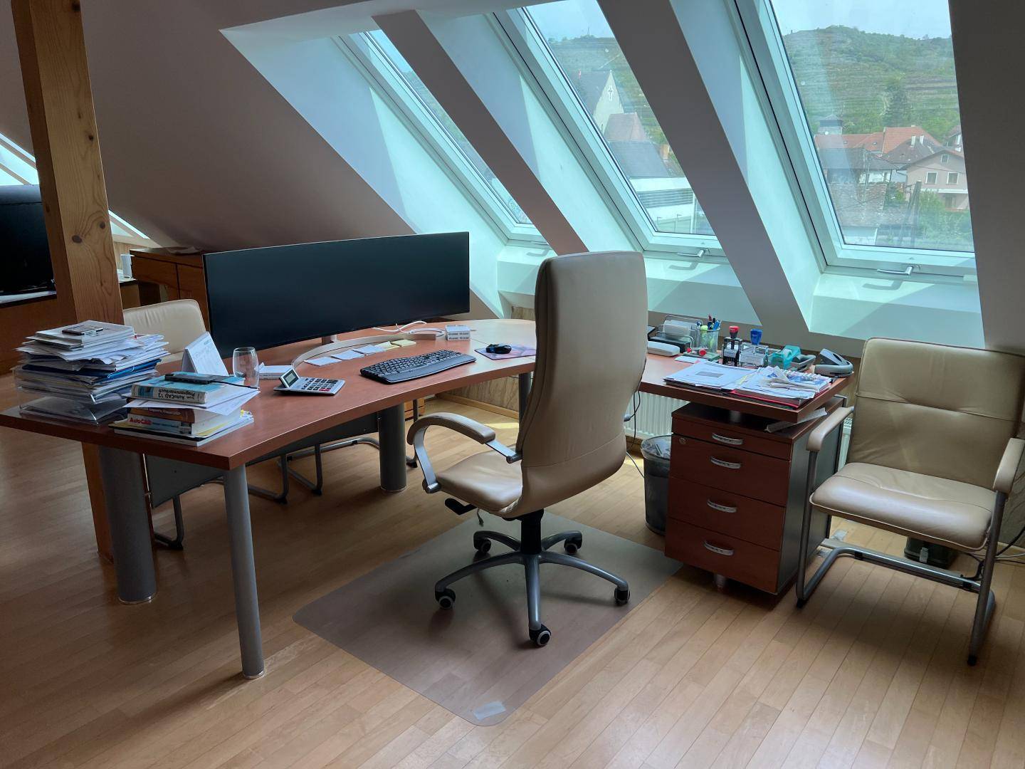 Geräumiges Dachgeschossbüro mit zwei Arbeitsplätzen, Holzboden und viel Tageslicht durch die Dachfenster.