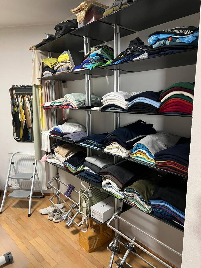 Geräumiger begehbarer Kleiderschrank mit offenen Regalen und viel Stauraum.