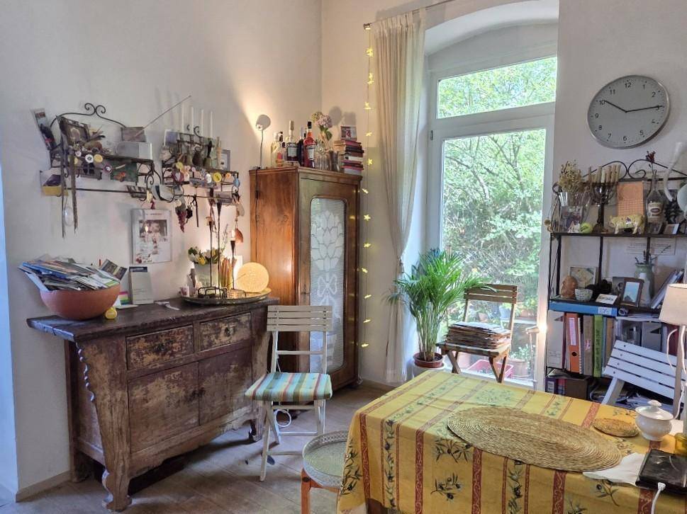 Heller Essbereich in der Küche mit Fensterblick ins Grüne und rustikalen Möbeln.