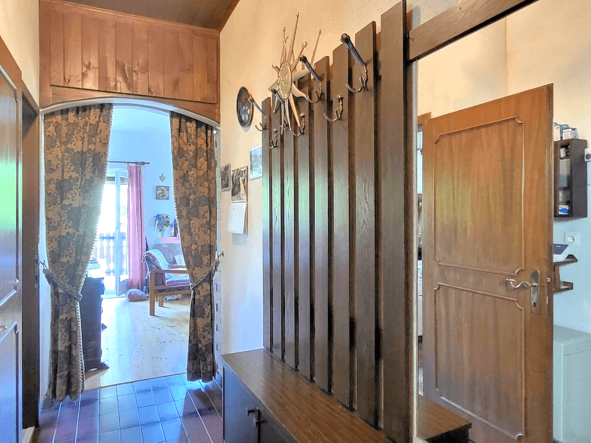 Traditioneller Eingangsbereich mit Holzvertäfelung, Garderobe und gefliestem Boden.