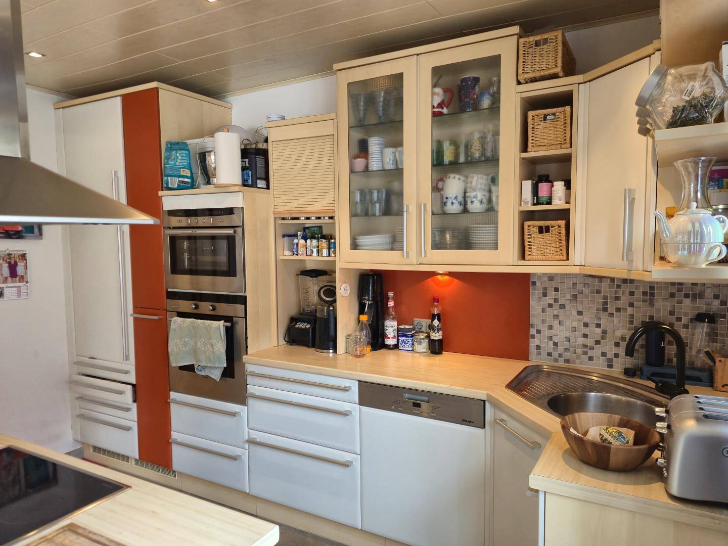Gut ausgestattete Küche mit hellen Fronten, Backofen und Kühlschrank, ideal für den täglichen Gebrauch.