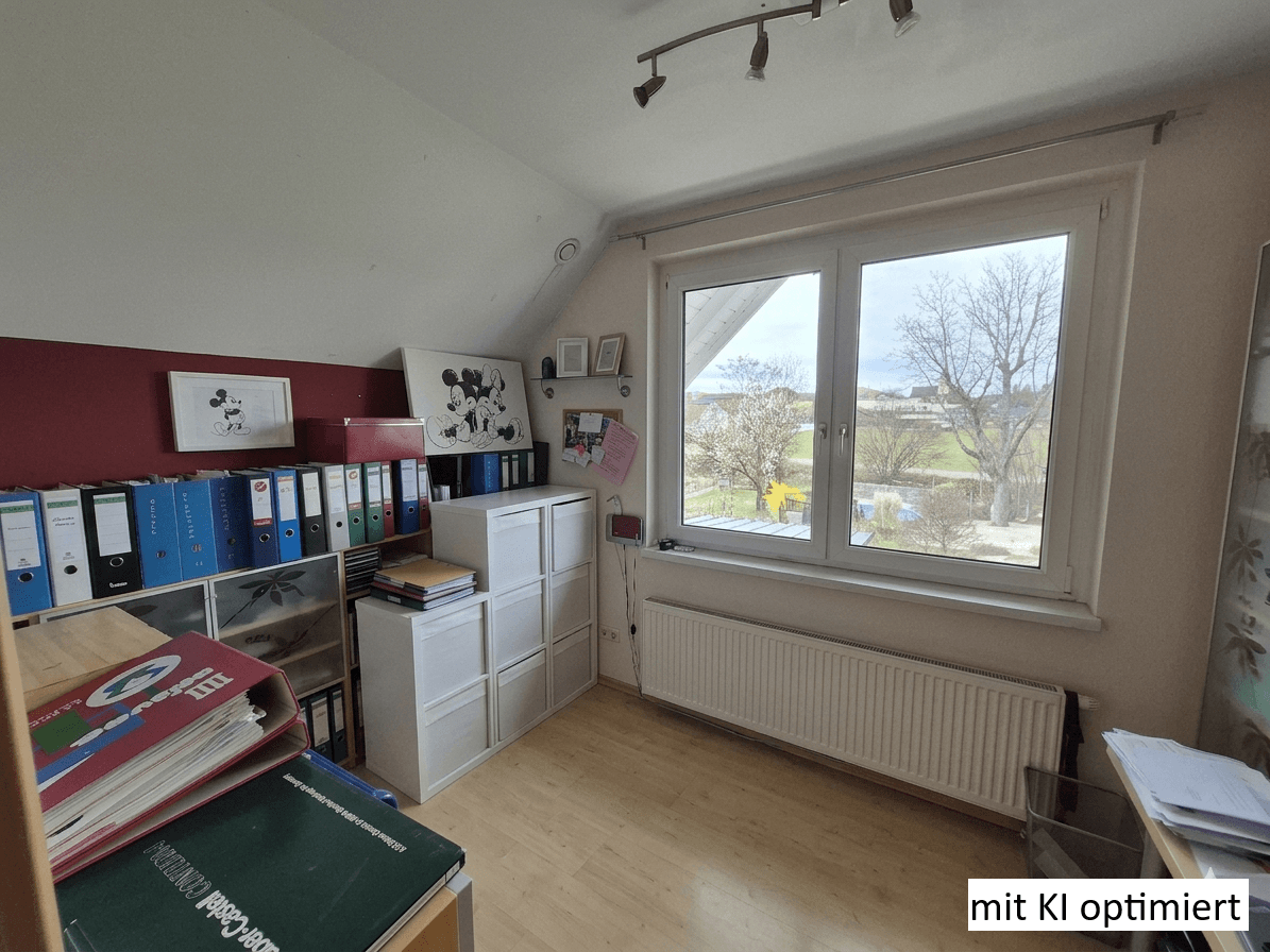Helles Arbeitszimmer mit großem Fenster, Blick ins Grüne und praktischen Regalsystemen.
