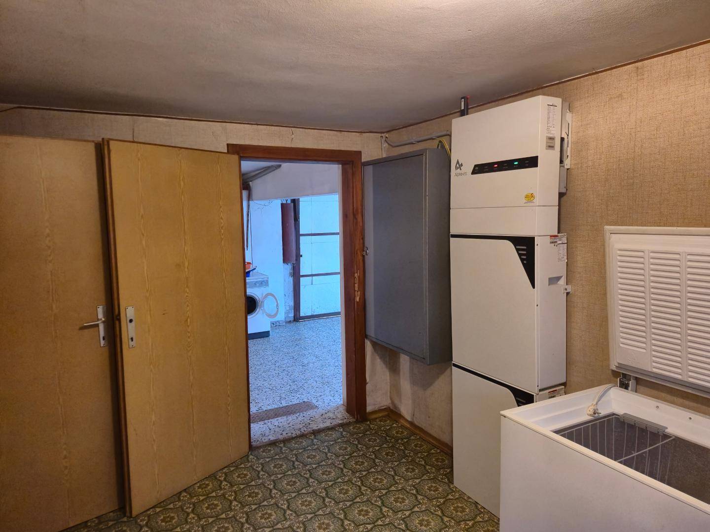 Hauswirtschaftsraum mit Gefriertruhe und weiteren Geräten, ideal für Lagerung.