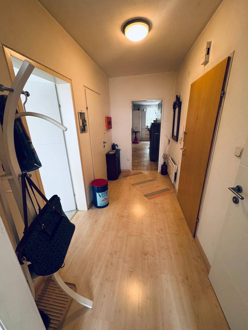 Eingangsbereich mit hellem Laminatboden, Garderobe und Zugang zu verschiedenen Zimmern.