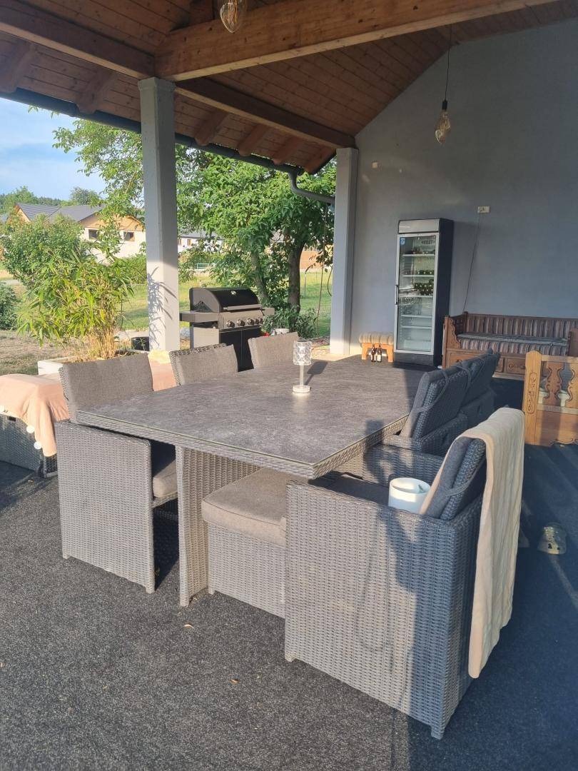 Geräumige überdachte Terrasse mit Grillbereich und Essgruppe für entspannte Stunden im Freien.