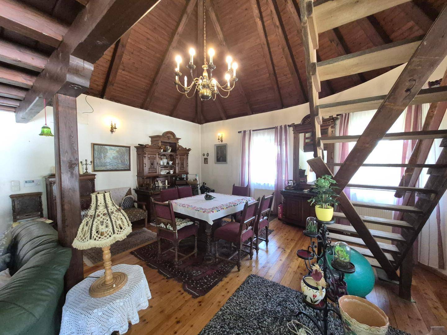 Geräumiger Wohn-Essbereich mit hoher Holzdecke, Holzboden und traditionellen Möbeln.