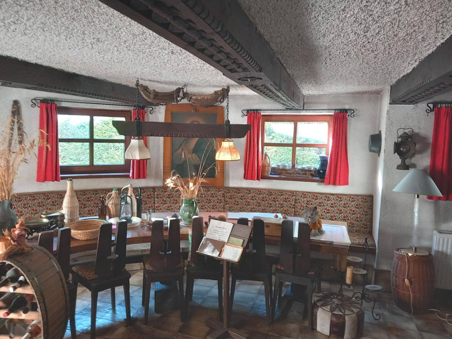 Rustikaler Essbereich mit großem Holztisch, eingebauter Sitzbank und traditioneller Dekoration.