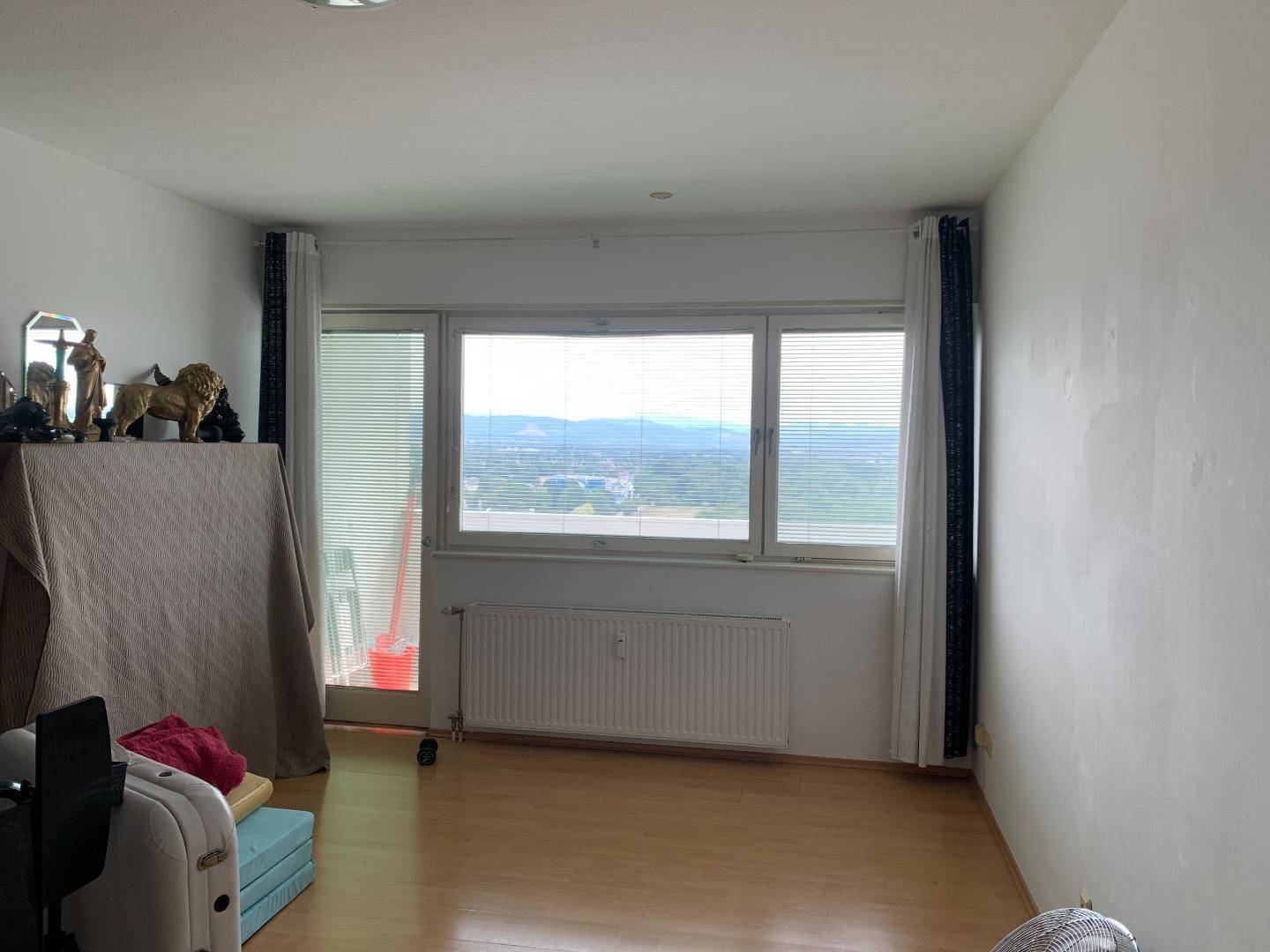 Helles Wohnzimmer mit Parkettboden, großen Fenstern und weitem Blick ins Grüne.