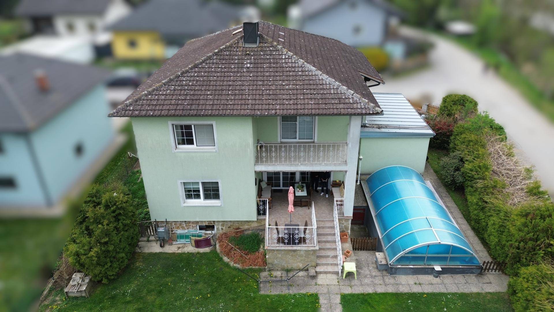 Luftaufnahme des Hauses mit Garten, Terrasse und überdachtem Pool in ländlicher Umgebung.