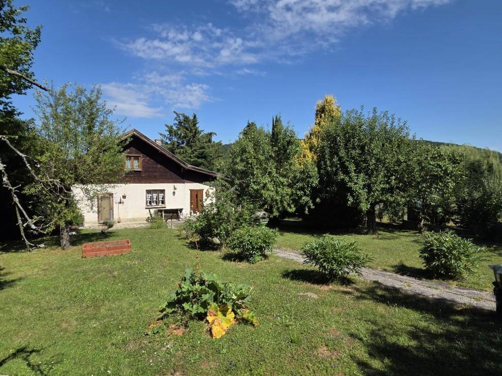 Charmantes Landhaus mit traditioneller Fassade, umgeben von einem weitläufigen, grünen Garten.