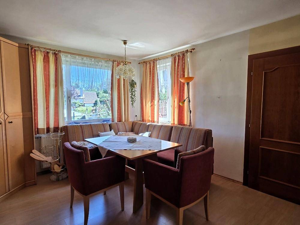 Heller Wohn-Essbereich mit großer Eckbank, Esstisch und Blick in den Garten.
