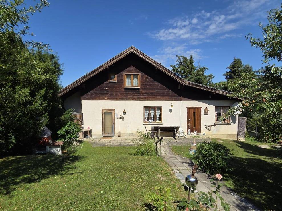 Traditionelles Haus mit Satteldach und gepflegtem Vorgarten, inklusive gepflastertem Weg.
