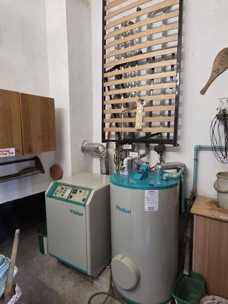 Heizungsraum mit Vaillant Heizkessel und Warmwasserspeicher, funktional eingerichtet.