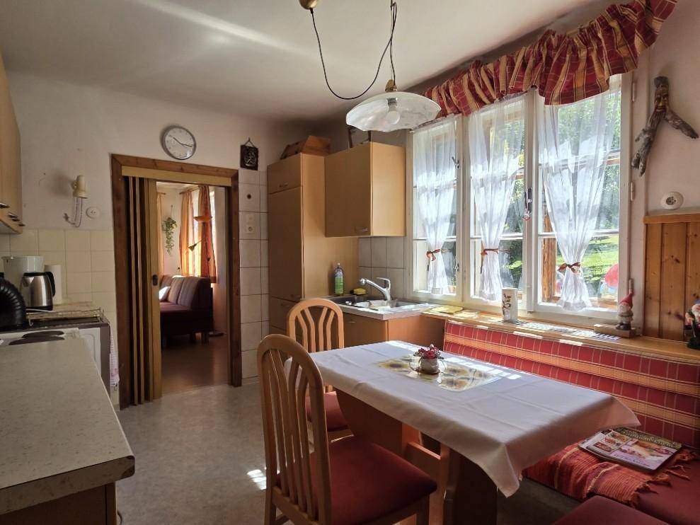Helle Wohnküche mit Esstisch, Fensterbank und Durchgang zu einem weiteren Raum.