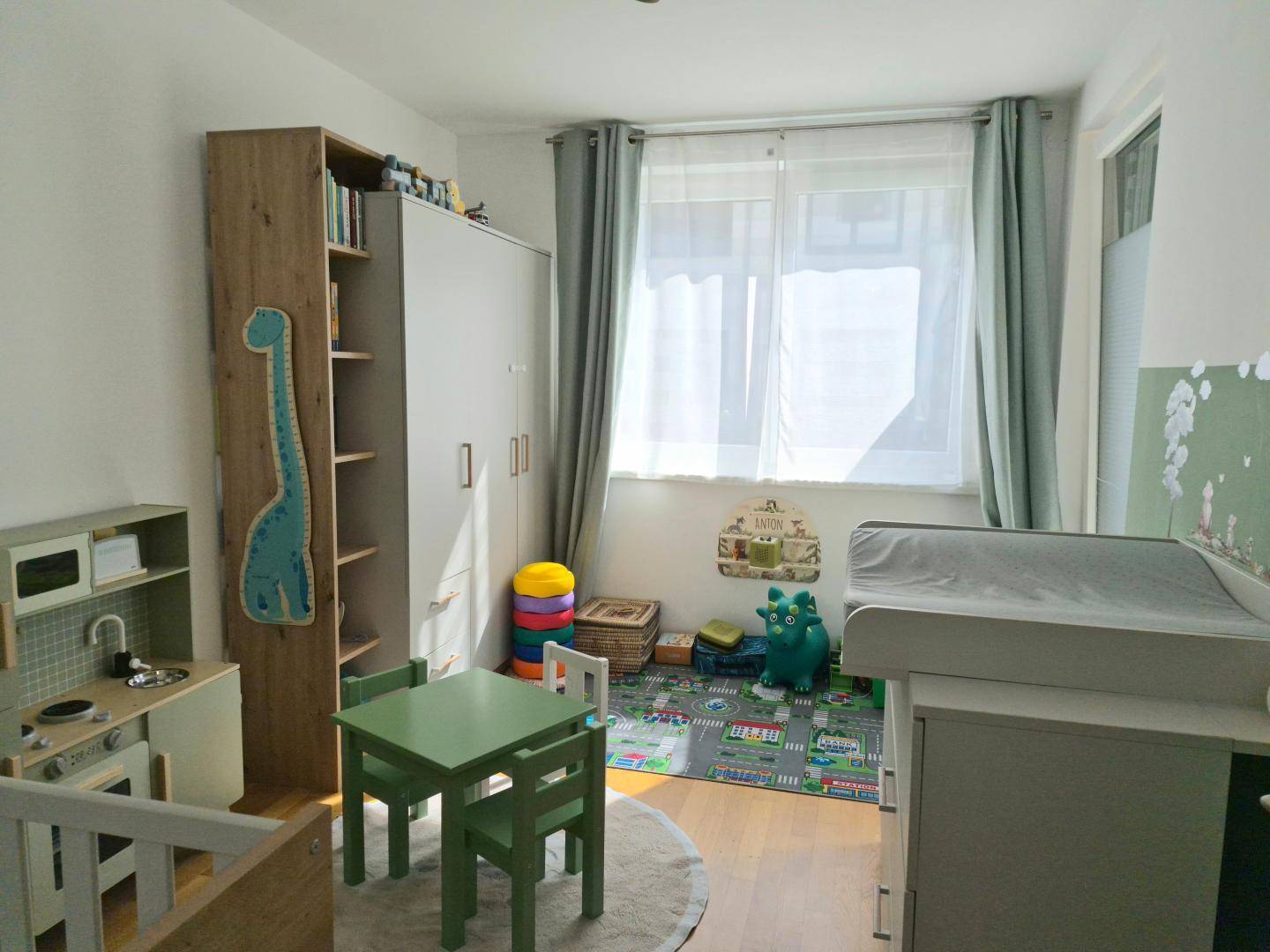 Helles Kinderzimmer mit Spielbereich, Wickeltisch und viel Stauraum für die Kleinen.