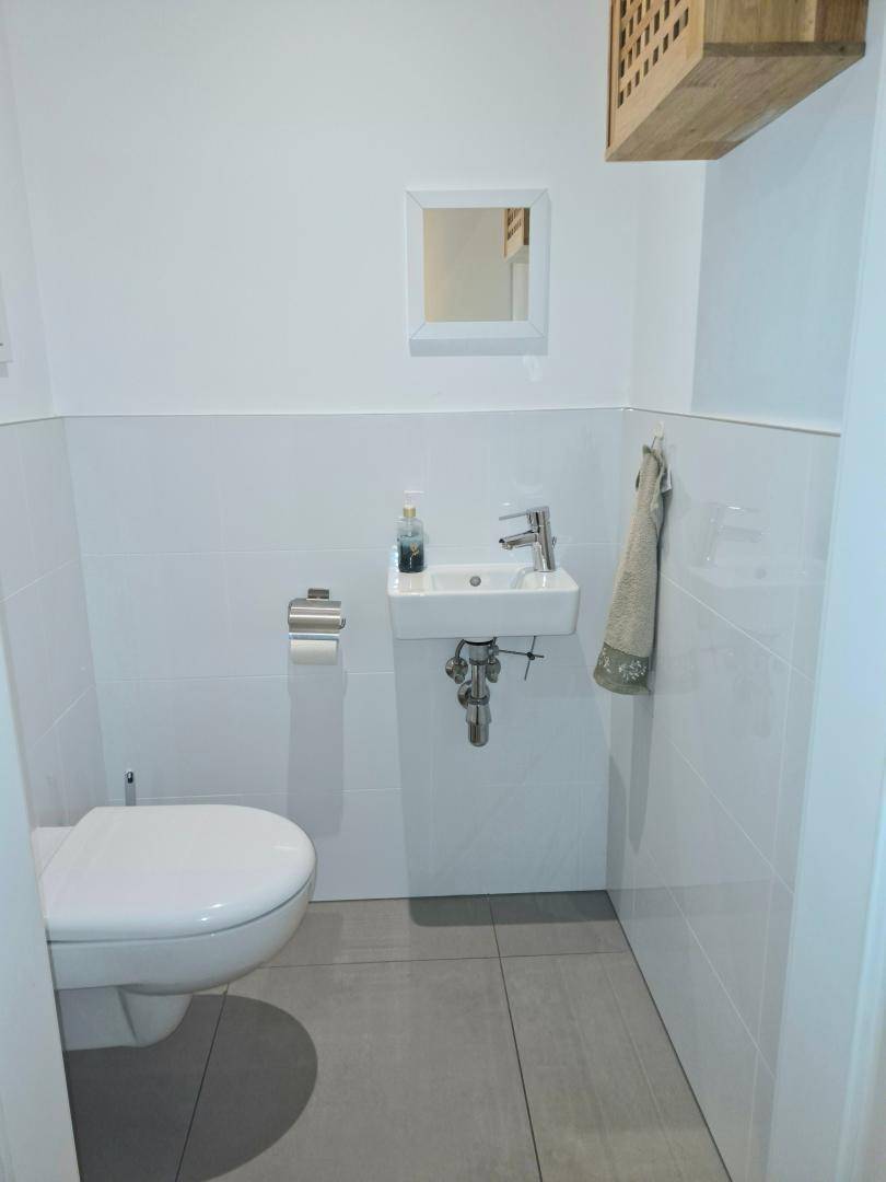 Kleines Gäste-WC mit wandhängender Toilette und modernem Waschbecken.