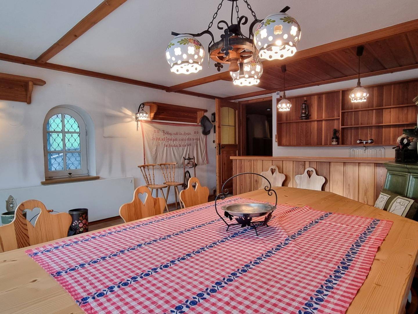 Gemütlicher Essbereich im alpinen Stil mit Holztisch, Bänken und traditioneller Dekoration.