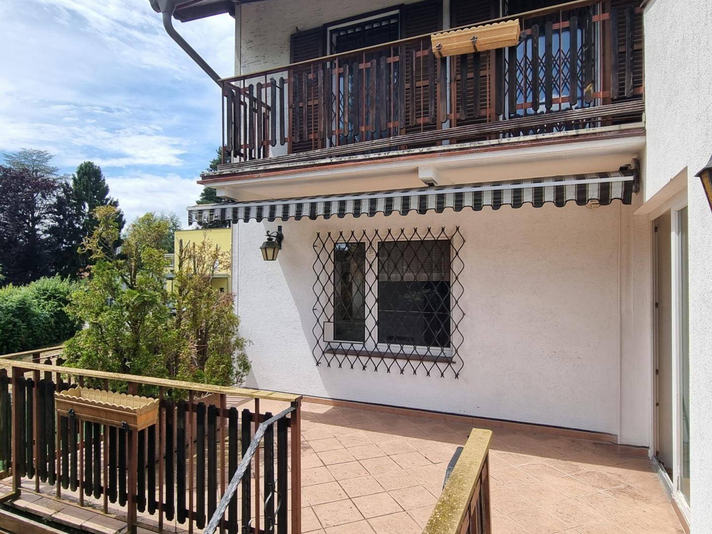 Balkon mit Markise und schmiedeeisernen Fenstergittern, bietet Schutz und Privatsphäre.