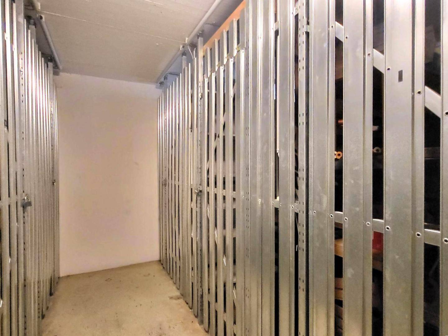 Kellerabteil mit Metallgittern für zusätzlichen Stauraum im Untergeschoss.