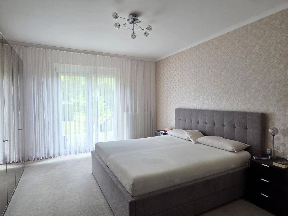 Modernes Schlafzimmer mit Doppelbett, Einbauschränken und Zugang zu einem Außenbereich.