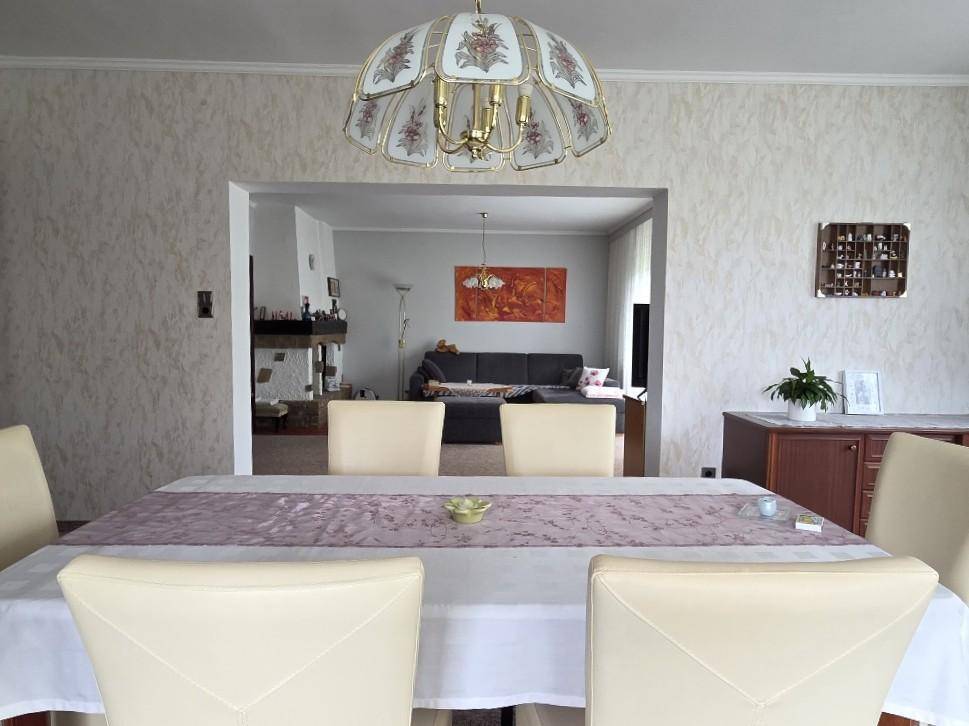 Offener Essbereich mit Übergang zum gemütlichen Wohnzimmer, ausgestattet mit Kamin.