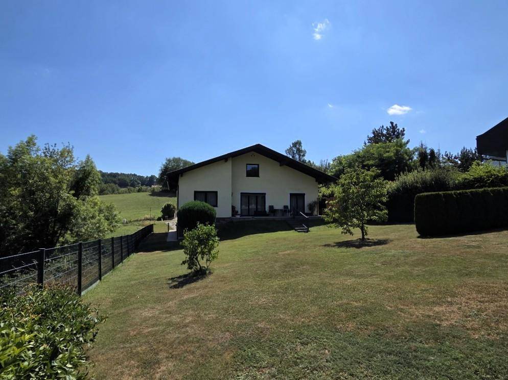 Freistehendes Haus mit großem Garten und weitem Blick auf die hügelige Landschaft.