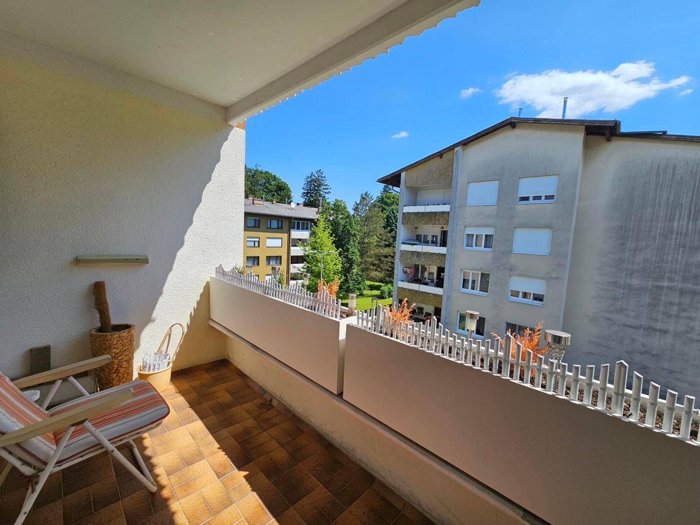 Geräumiger Balkon mit Fliesenboden und Liegestuhl, ideal zum Entspannen im Freien.