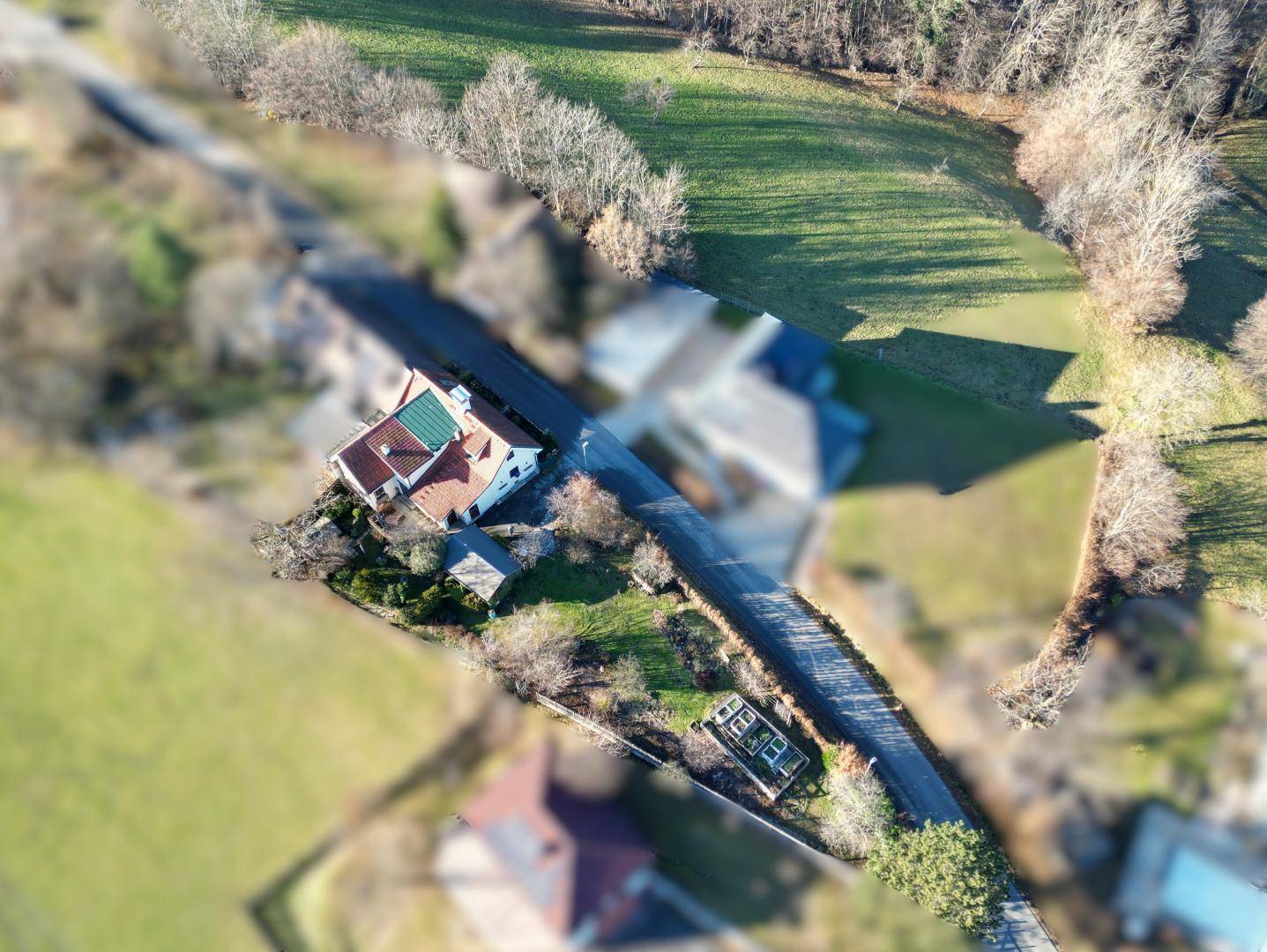 Luftaufnahme des Anwesens mit Haus, Garten und umliegender Landschaft.