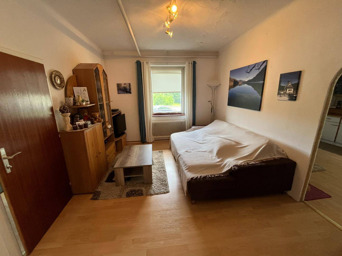 Helles Wohnzimmer mit Sofa, kleinem Couchtisch und Blick ins Grüne.
