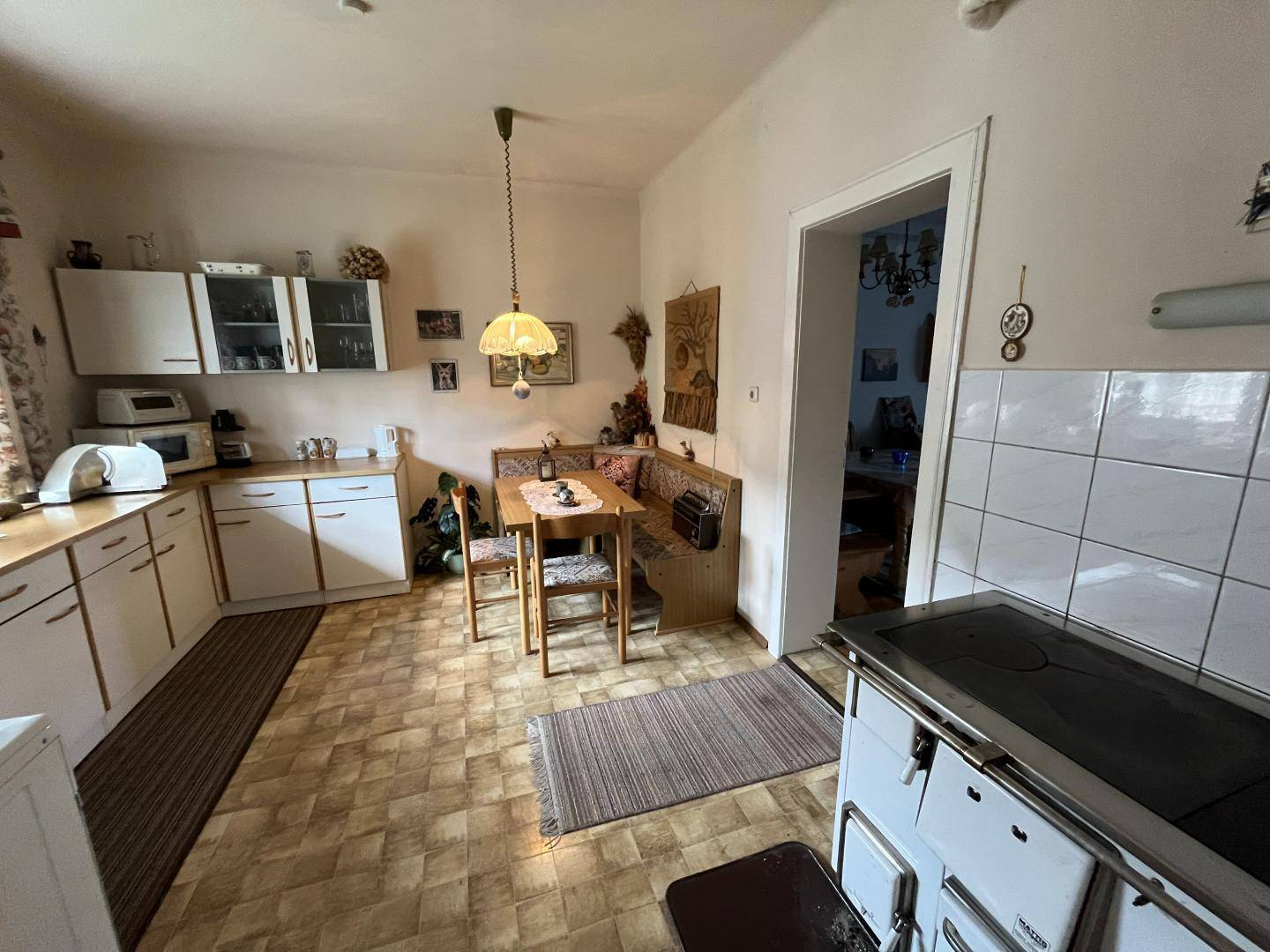 Traditionelle Küche mit Essecke, Holzofen und einfacher Ausstattung.
