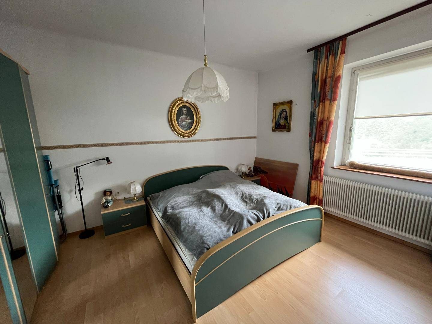 Schlafzimmer mit Doppelbett, Nachttischen und Fenster mit Blick nach draußen.