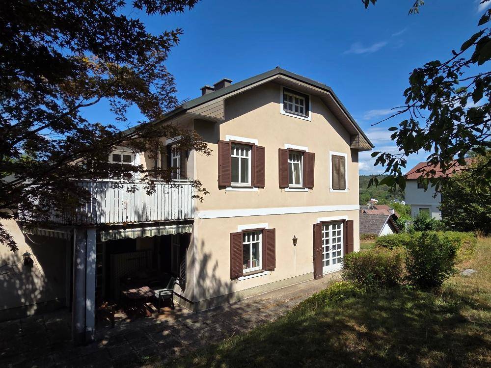 Ansicht des Hauses von der Seite mit Balkon und Carport.