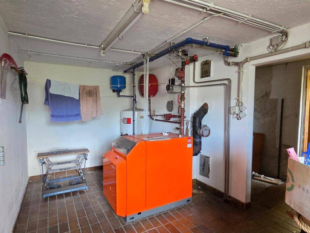 Heizungsraum mit moderner Heizungsanlage und Fliesenboden.