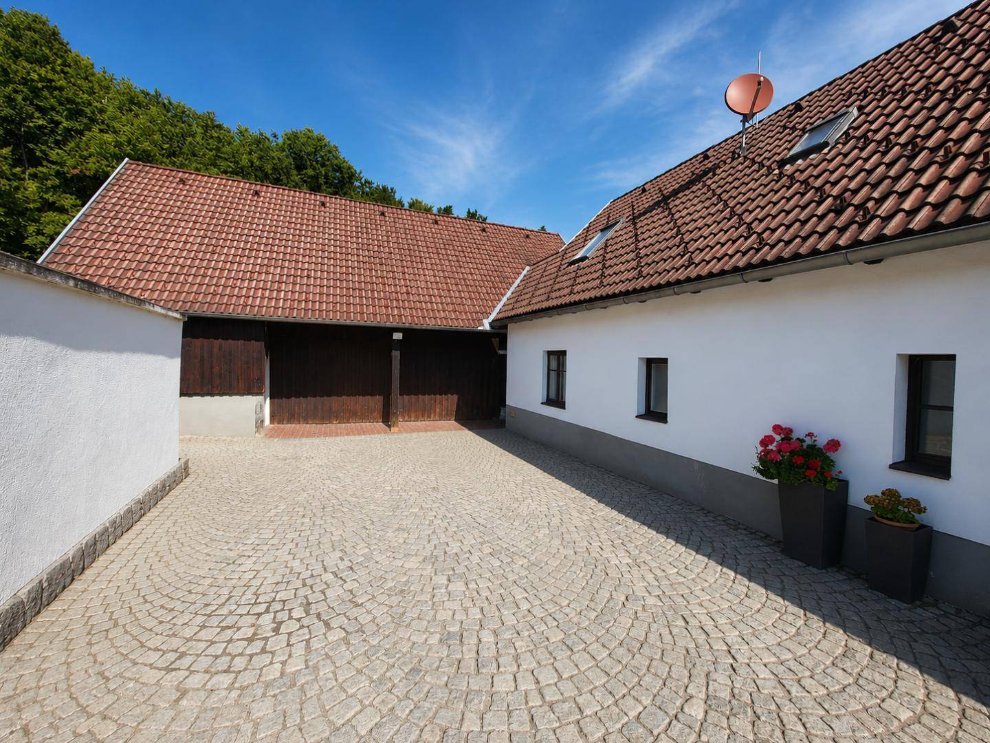 Gepflasterter Innenhof mit Kopfsteinpflaster zwischen den Gebäudeteilen, bietet Zugang und Stellfläche.