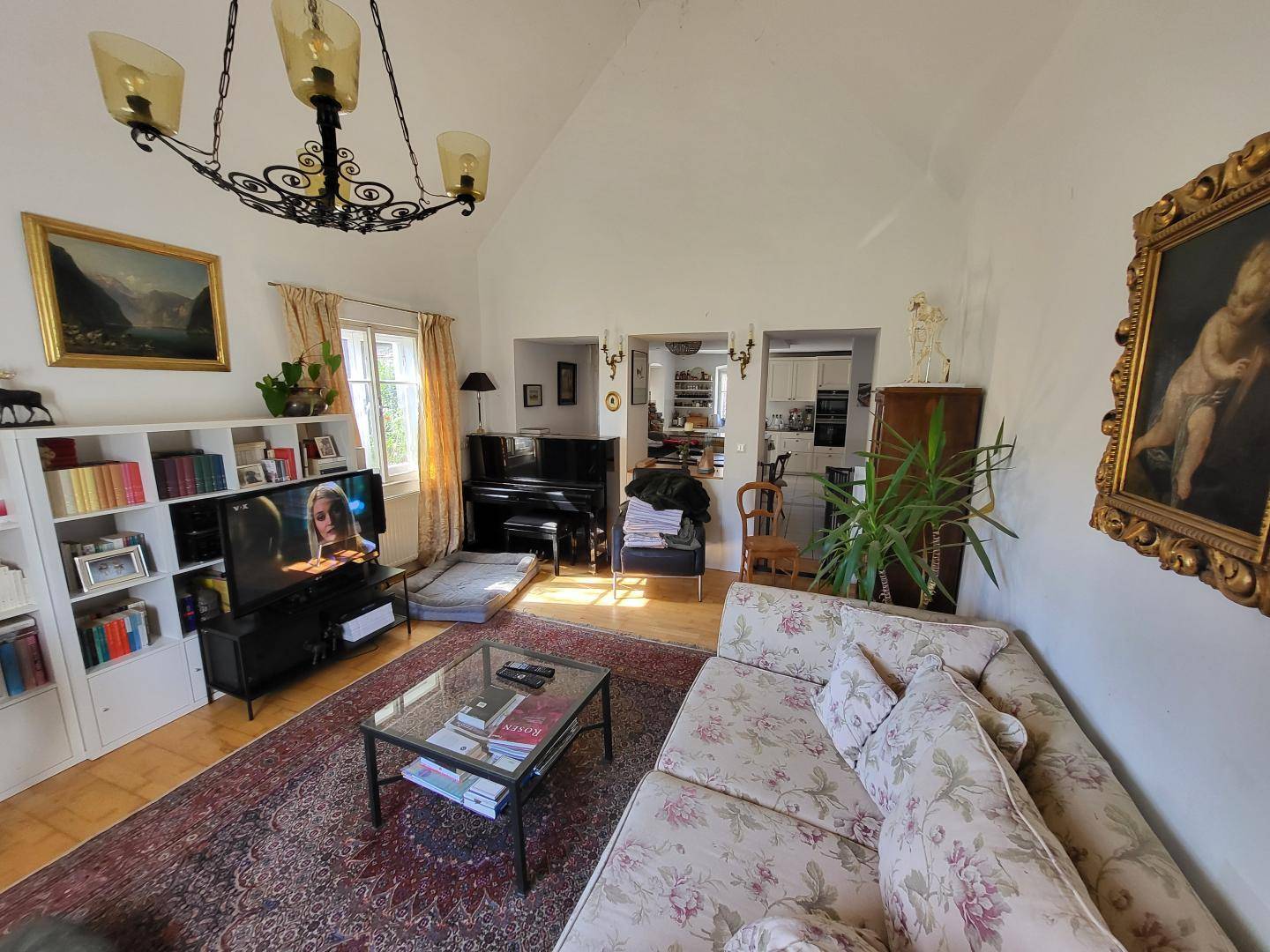 Gemütliches Wohnzimmer mit Sofa, Teppich, Bücherregalen und Blick in den angrenzenden Essbereich.