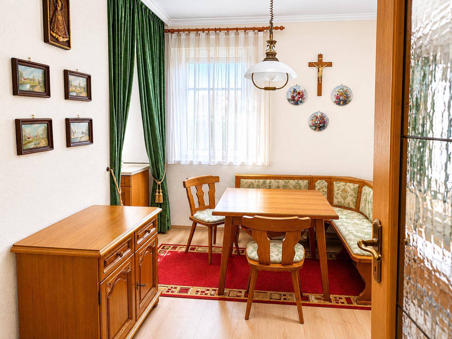 Gemütlicher Essbereich mit Eckbank, Holztisch und traditioneller Dekoration in warmen Farben.