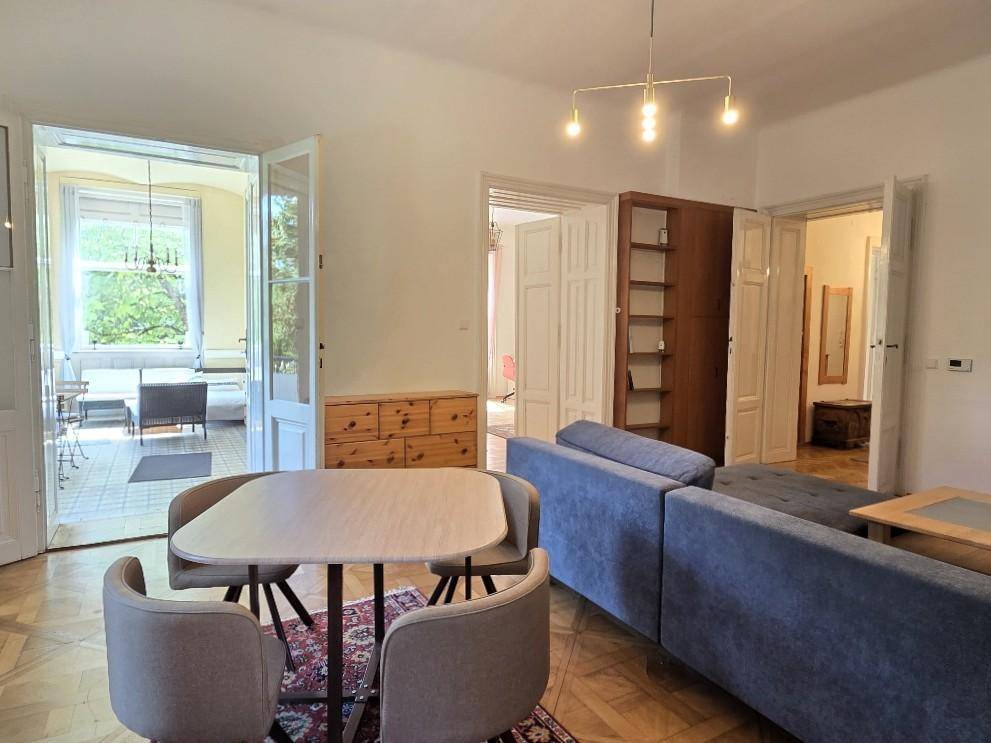 Wohnbereich mit Zugang zur Loggia und Blick in angrenzende Zimmer, hell und geräumig.