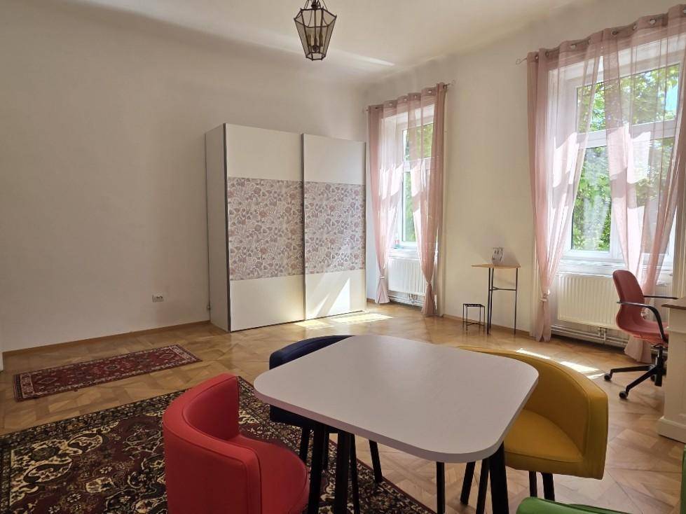 Vielseitiges Zimmer mit Schiebetürenschrank und hellem Fischgrätparkett, gut beleuchtet.