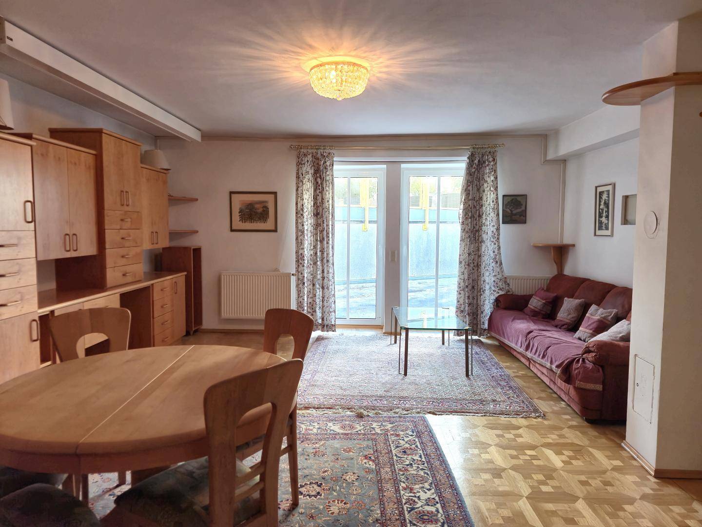 Geräumiger Wohn- und Essbereich mit Sofa, Esstisch und Zugang zum Außenbereich.