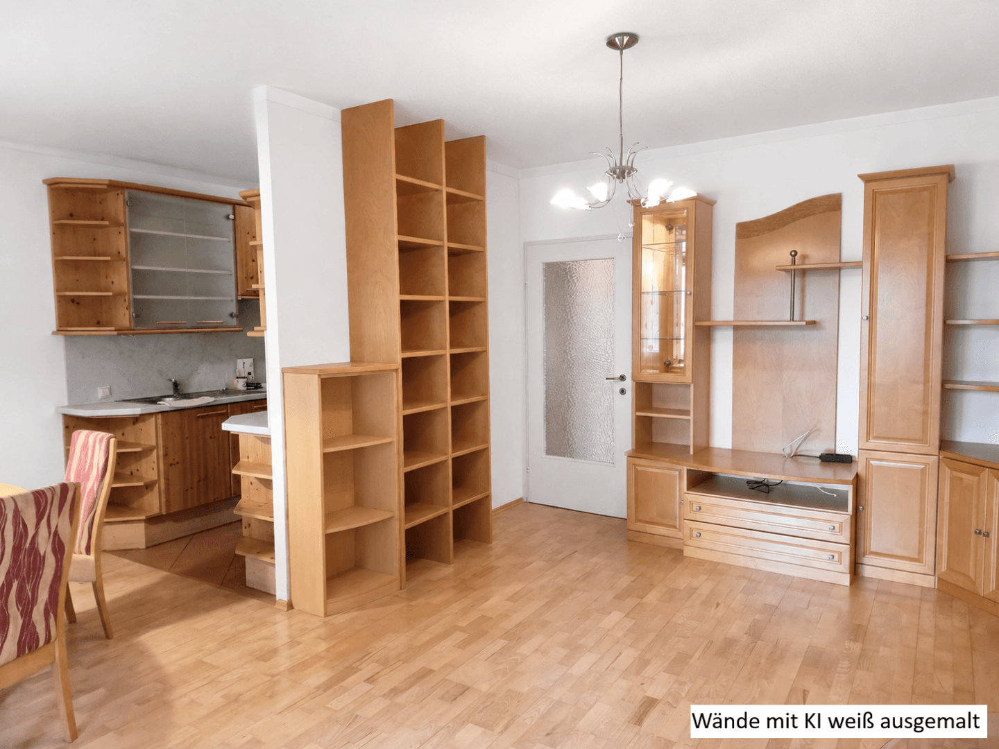 Heller Wohnbereich mit Holzmöbeln und integrierter Küche, Wände weiß gestrichen für ein modernes Ambiente.