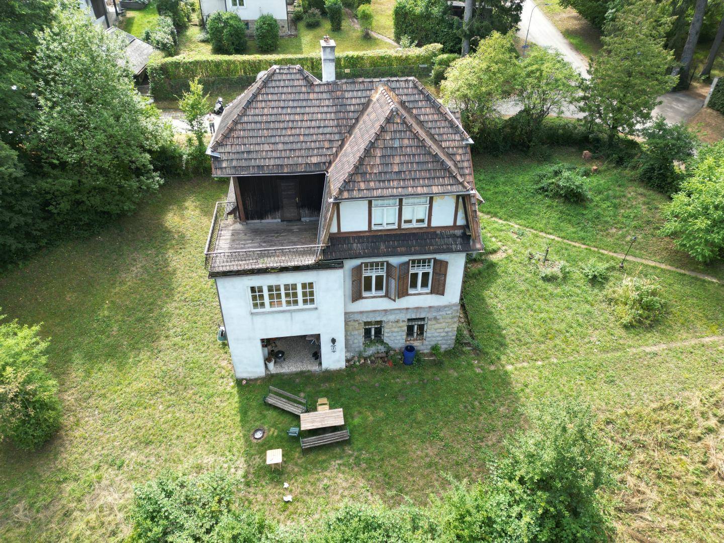 Vogelperspektive auf ein älteres Wohnhaus mit Satteldach und großem Grundstück.