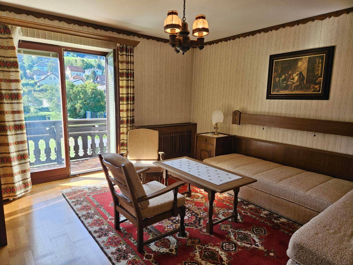 Gemütliches Schlafzimmer im traditionellen Stil mit Balkonzugang und Blick auf die grüne Umgebung.