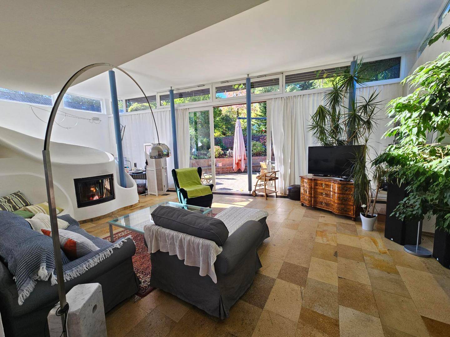 Heller Wohnraum mit Kamin, bequemen Sofas und direktem Zugang zur Außenterrasse.