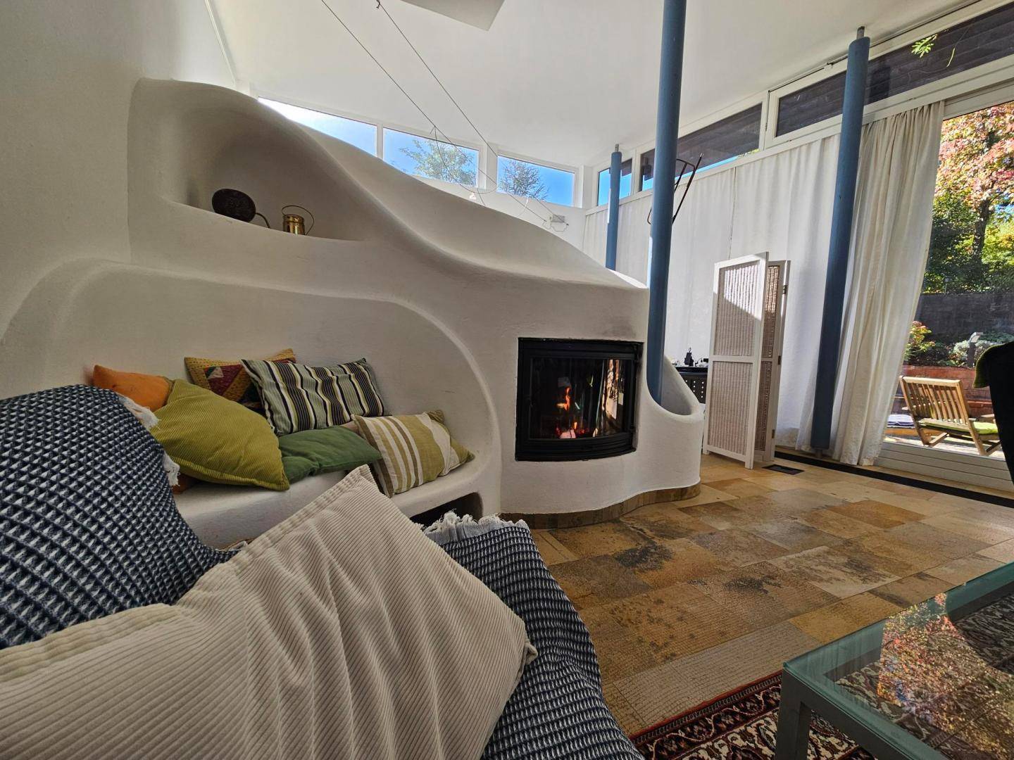 Detailansicht des modernen Kamins im Wohnzimmer, umgeben von bequemen Sitzgelegenheiten.