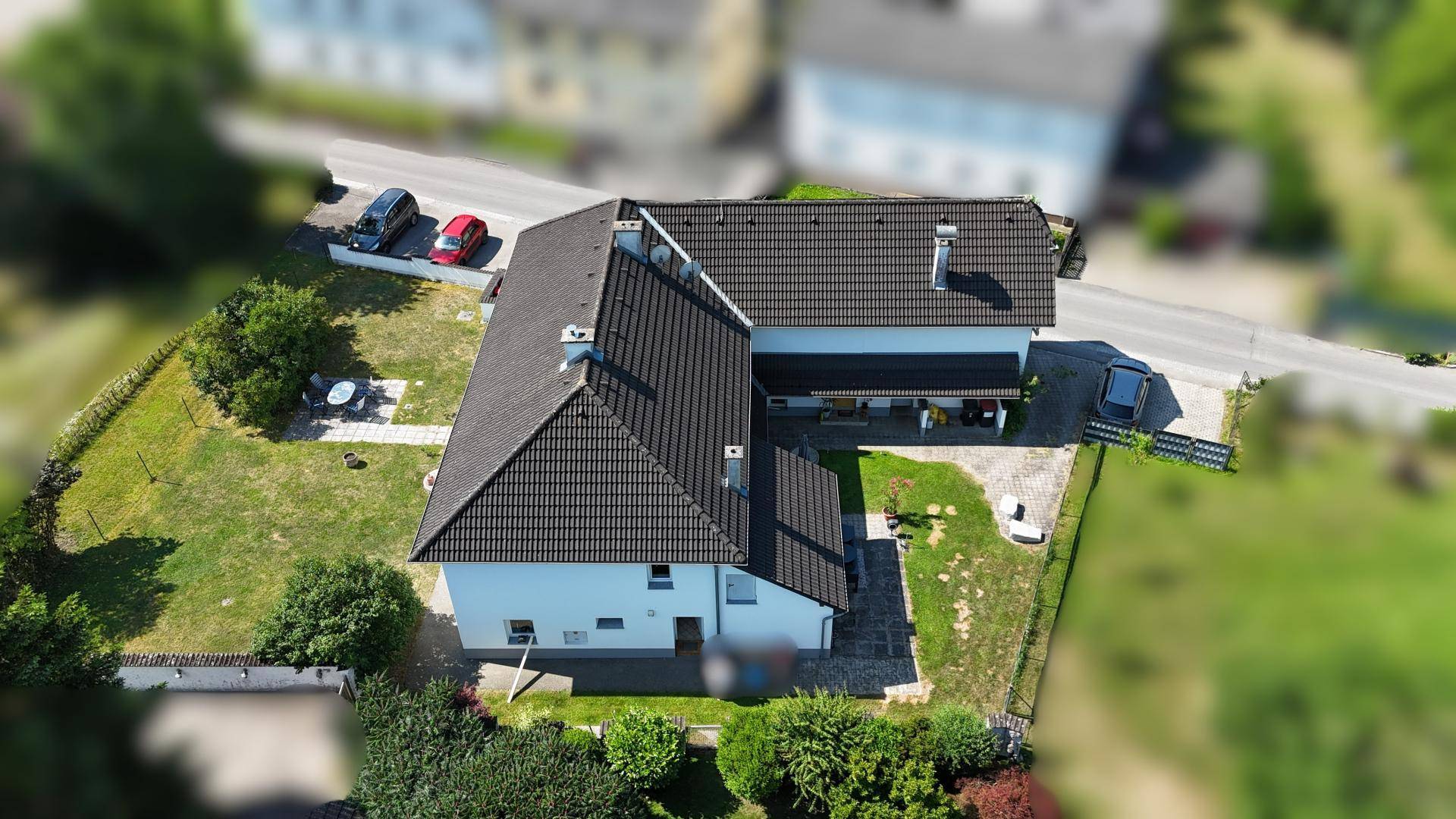 Luftaufnahme des Anwesens mit umliegender Grünfläche und Straße.