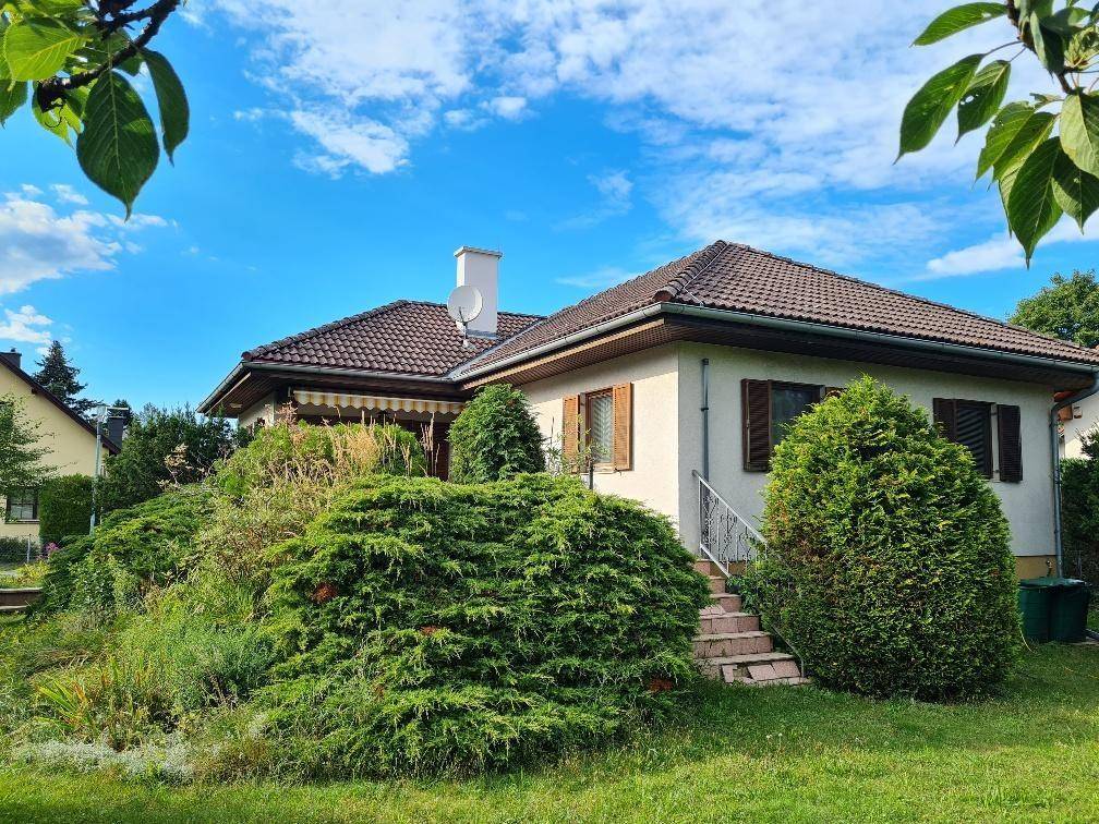 Charmantes Einfamilienhaus mit üppigem Grün und sonnigem Gartenbereich.