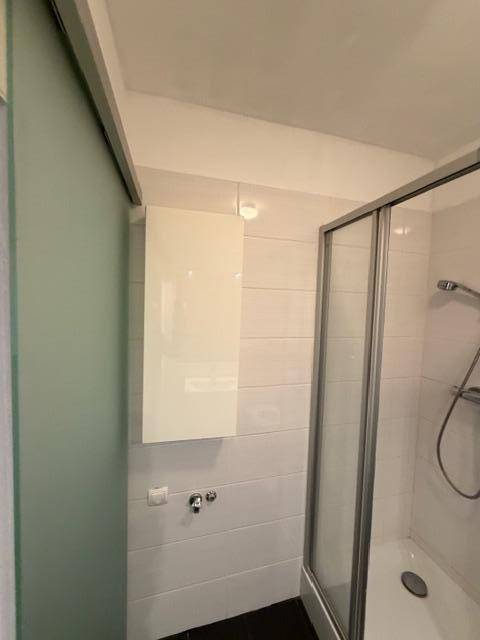 Badezimmer mit Duschkabine und einem praktischen Wandschrank.