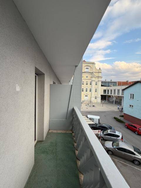 Balkon mit Blick auf die Straße und umliegende Gebäude in der Stadt.